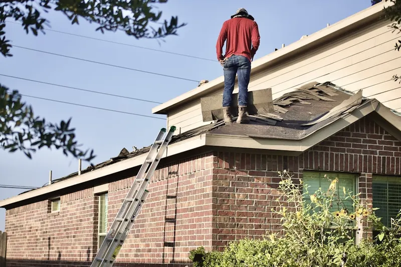 Professional roofer working on a residential roof in Fisherville